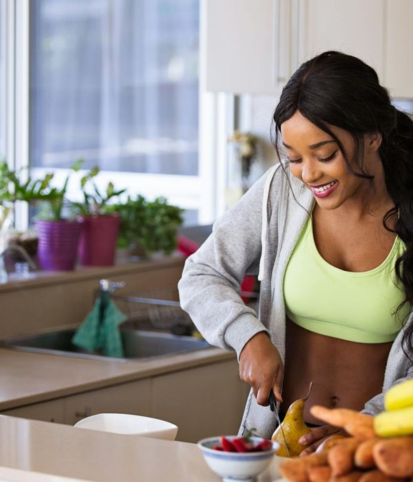 Smiling woman in sportswear feeling energetic at home.